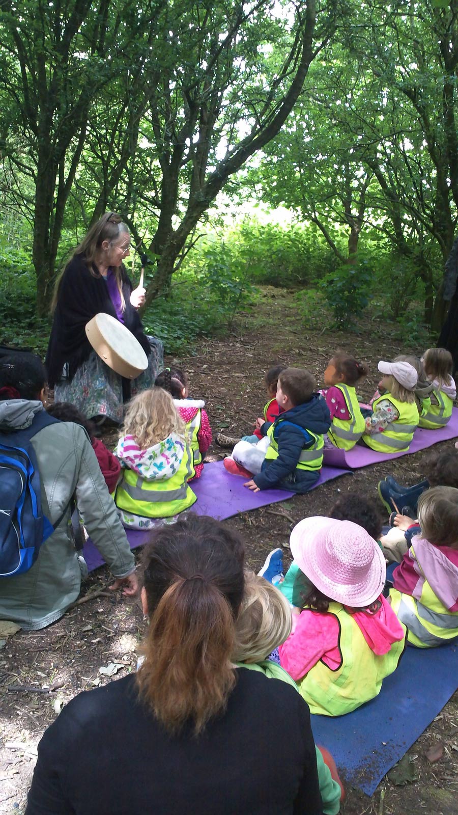 Ruth playing the drum and storytelling in the woods